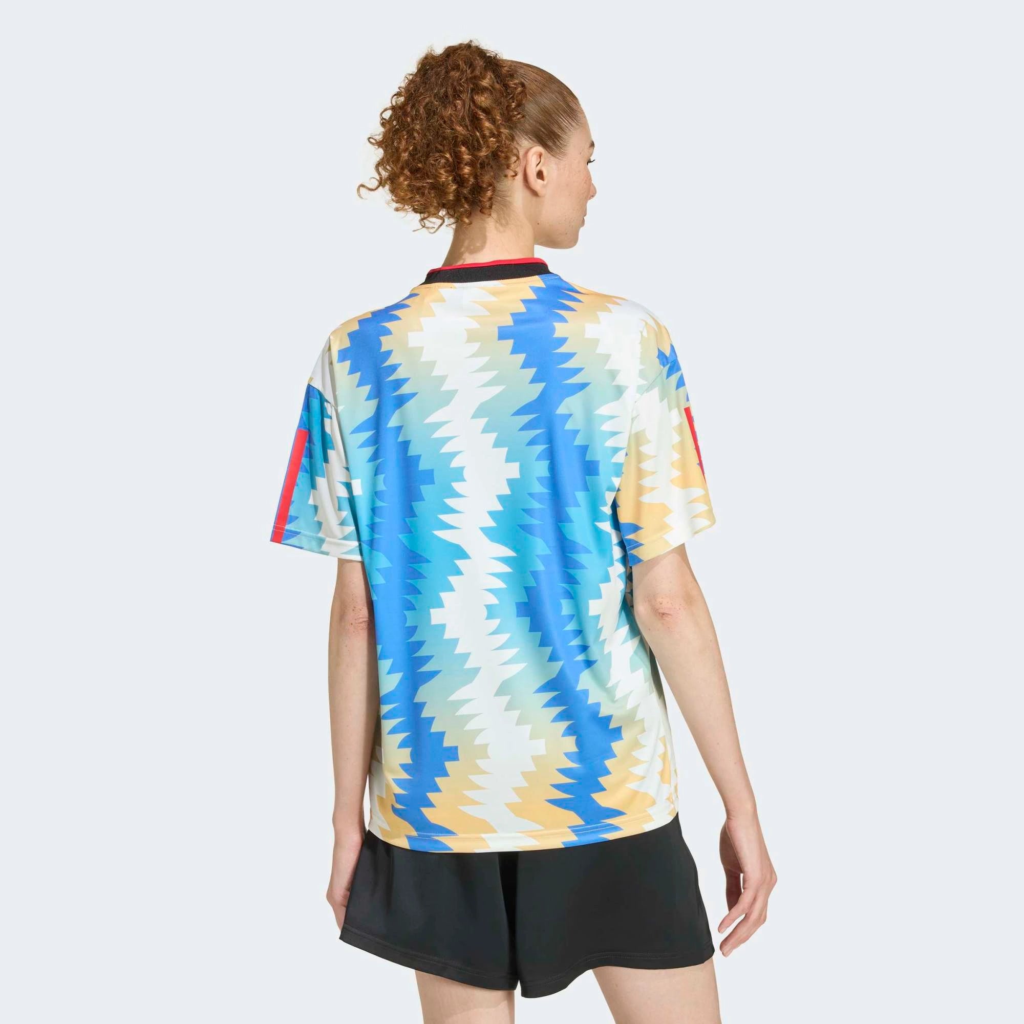 “Cremeweißes (Off White) adidas Originals Tiro x Common Goal Damen Trikot mit blauen Details und dezentem Allover-Print bei Stickabush.“