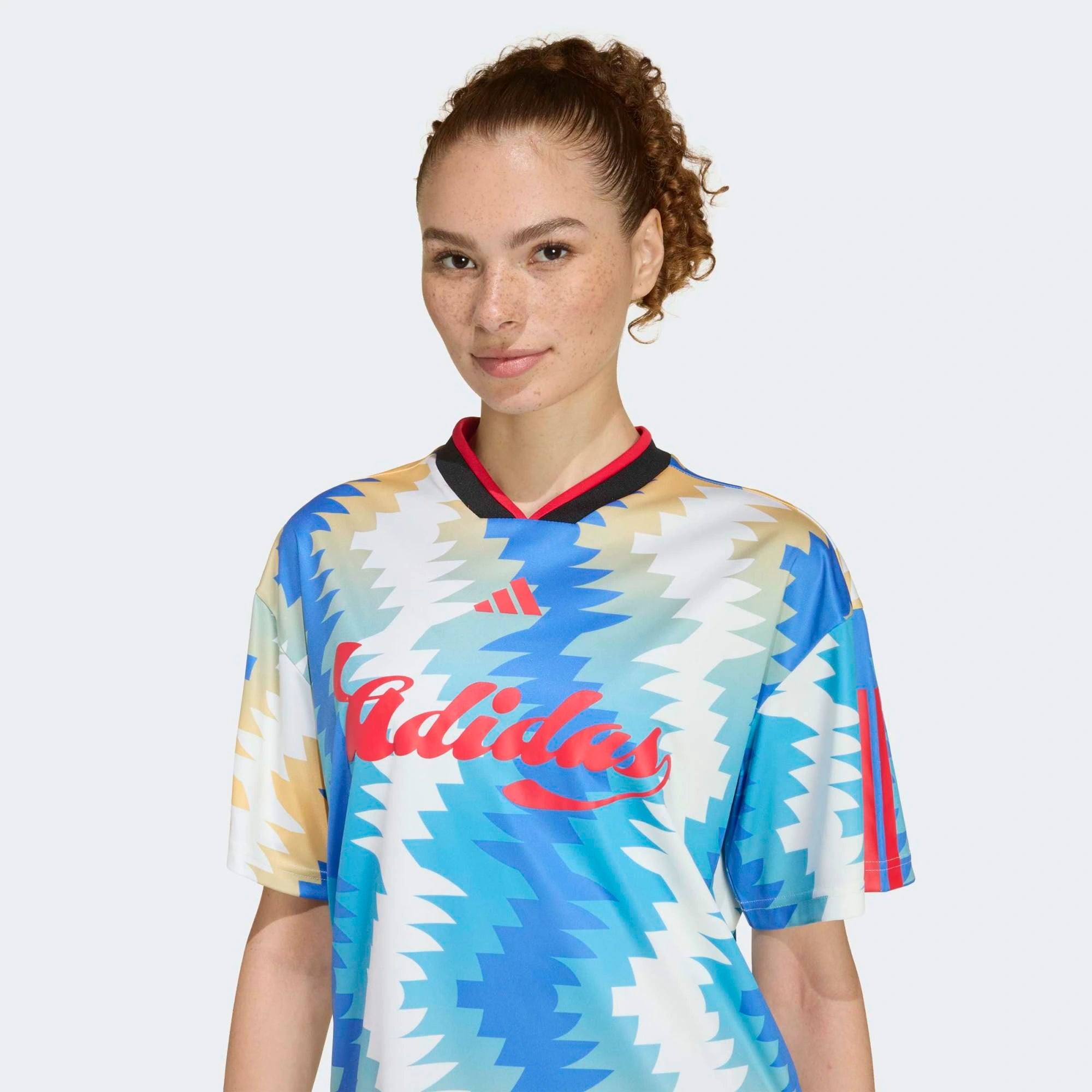 “Cremeweißes (Off White) adidas Originals Tiro x Common Goal Damen Trikot mit blauen Details und dezentem Allover-Print bei Stickabush.“