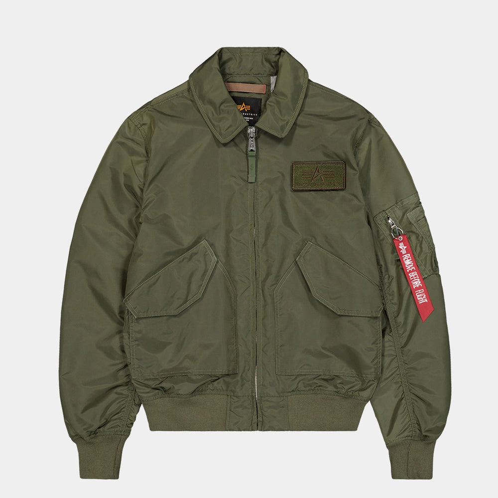 Alpha Industries CWU-36/P TT Light Bomberjacke in Dark Olive (266101-142) mit „Remove Before Flight“ Tag bei Stickabush Berlin.