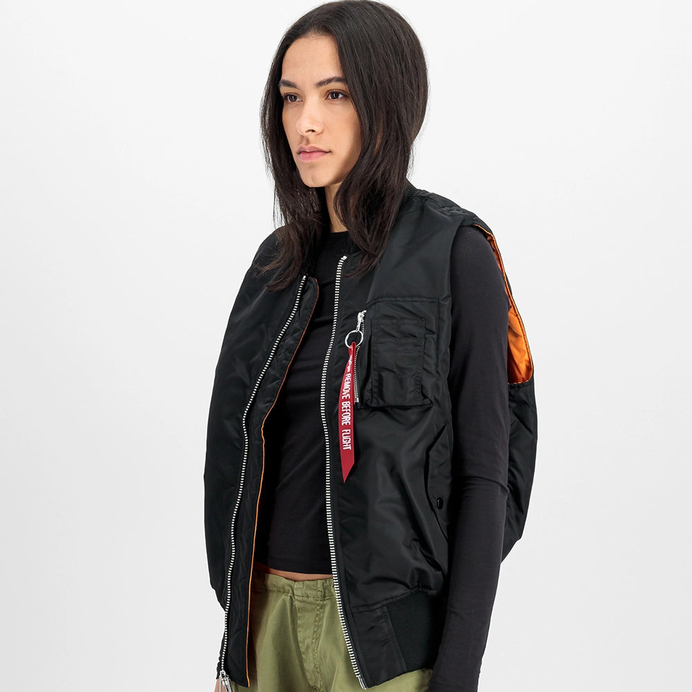 Schwarze Alpha Industries MA-1 Vest Heritage für Herren mit dem ikonischen roten Remove Before Flight Tag und orangenem Innenfutter bei Stickabush Berlin.