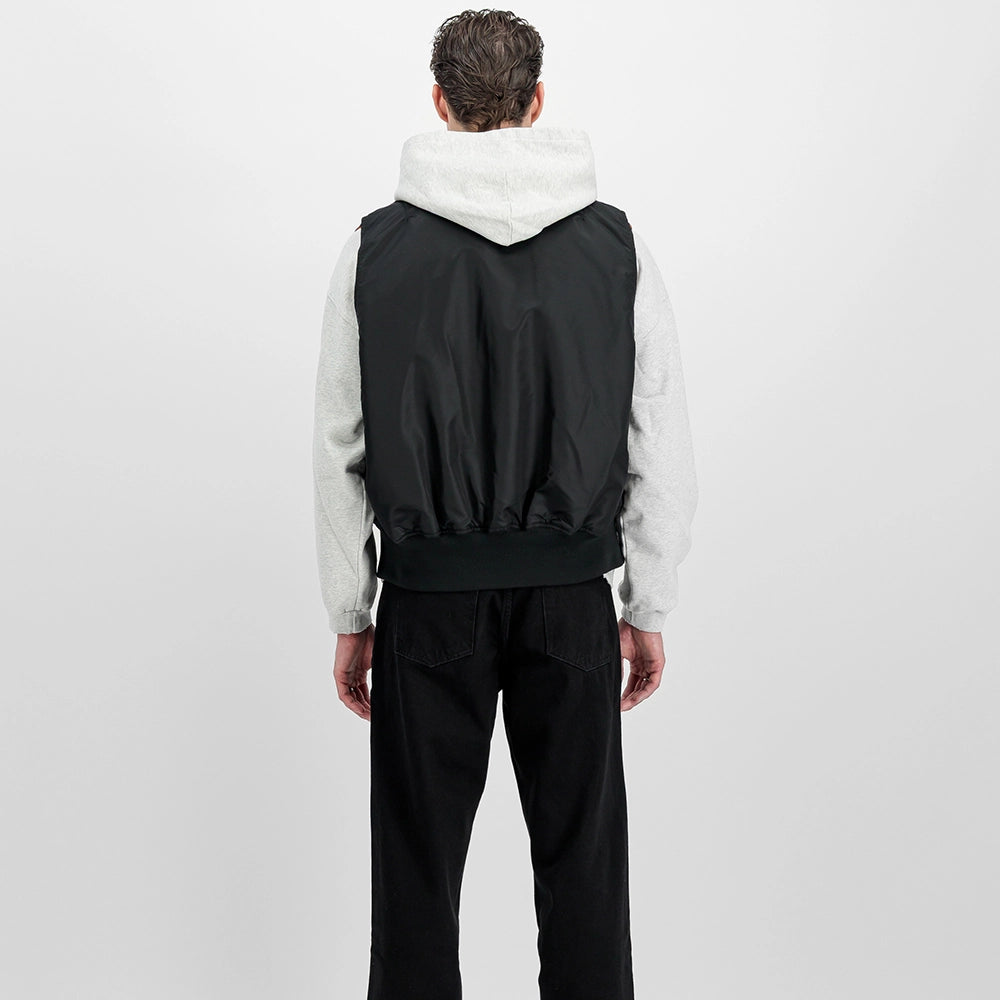 Schwarze Alpha Industries MA-1 Vest Heritage für Herren mit dem ikonischen roten Remove Before Flight Tag und orangenem Innenfutter bei Stickabush Berlin.