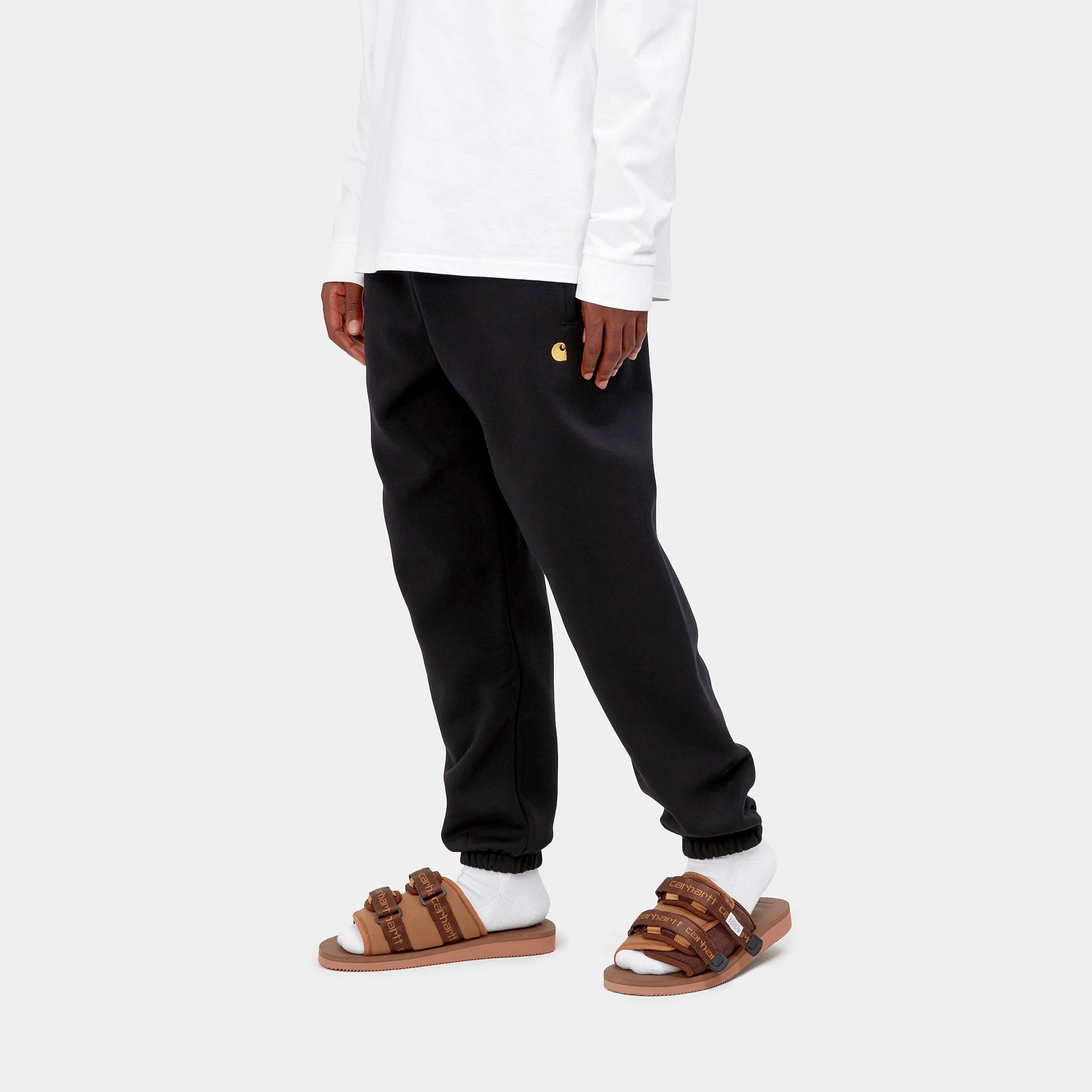 “Carhartt WIP Chase Sweat Pant in Black / Gold, eine Jogginghose aus weichem Baumwollmix, mit elastischem Bund und goldener Logo-Stickerei am Bein.“