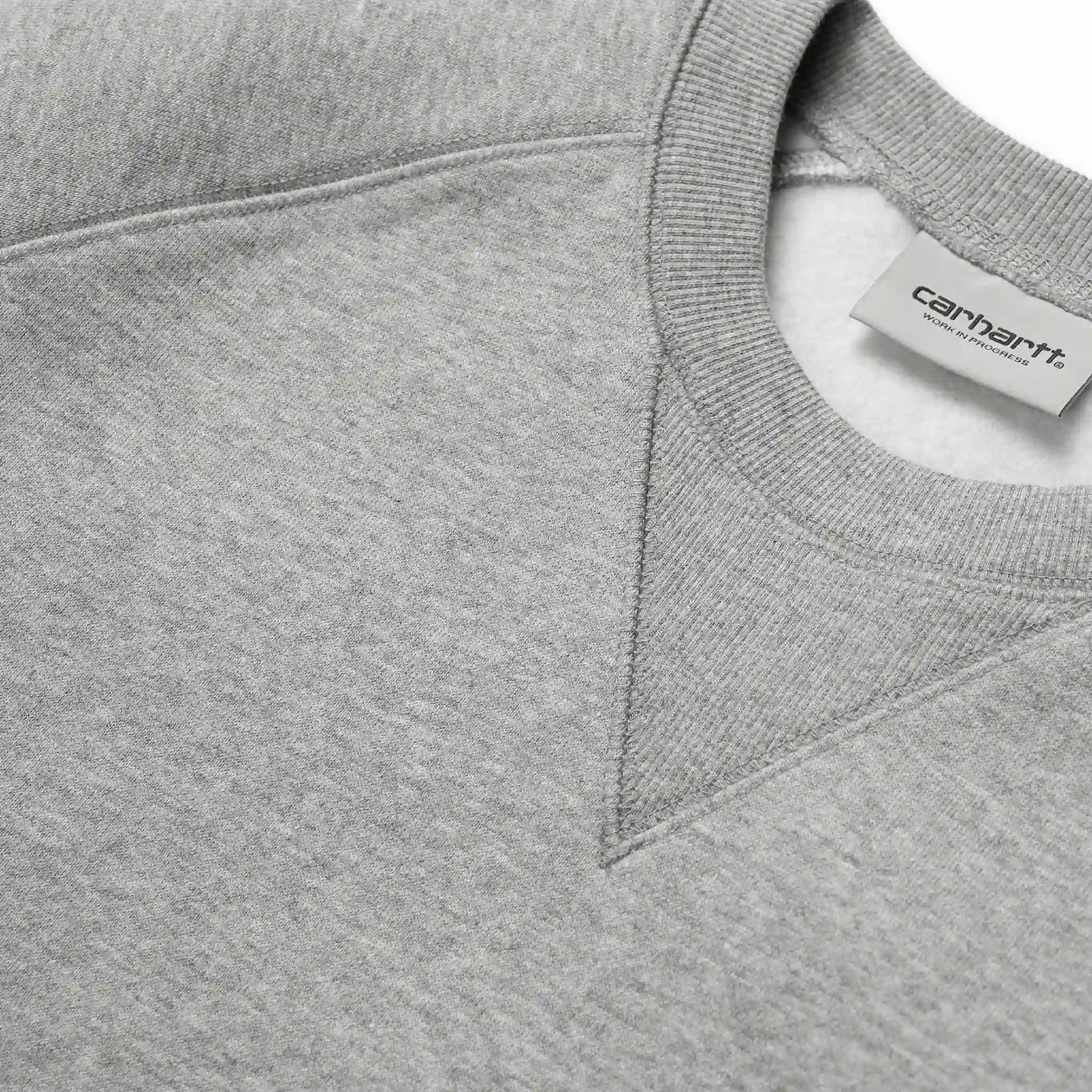 “Graumeliertes Carhartt WIP Chase Sweatshirt mit kleinem, goldenem "C"-Logo auf dem linken Ärmel. Klassischer Schnitt, Rundhalsausschnitt, gerippte Bündchen und Saum. Weicher Baumwollmix.“