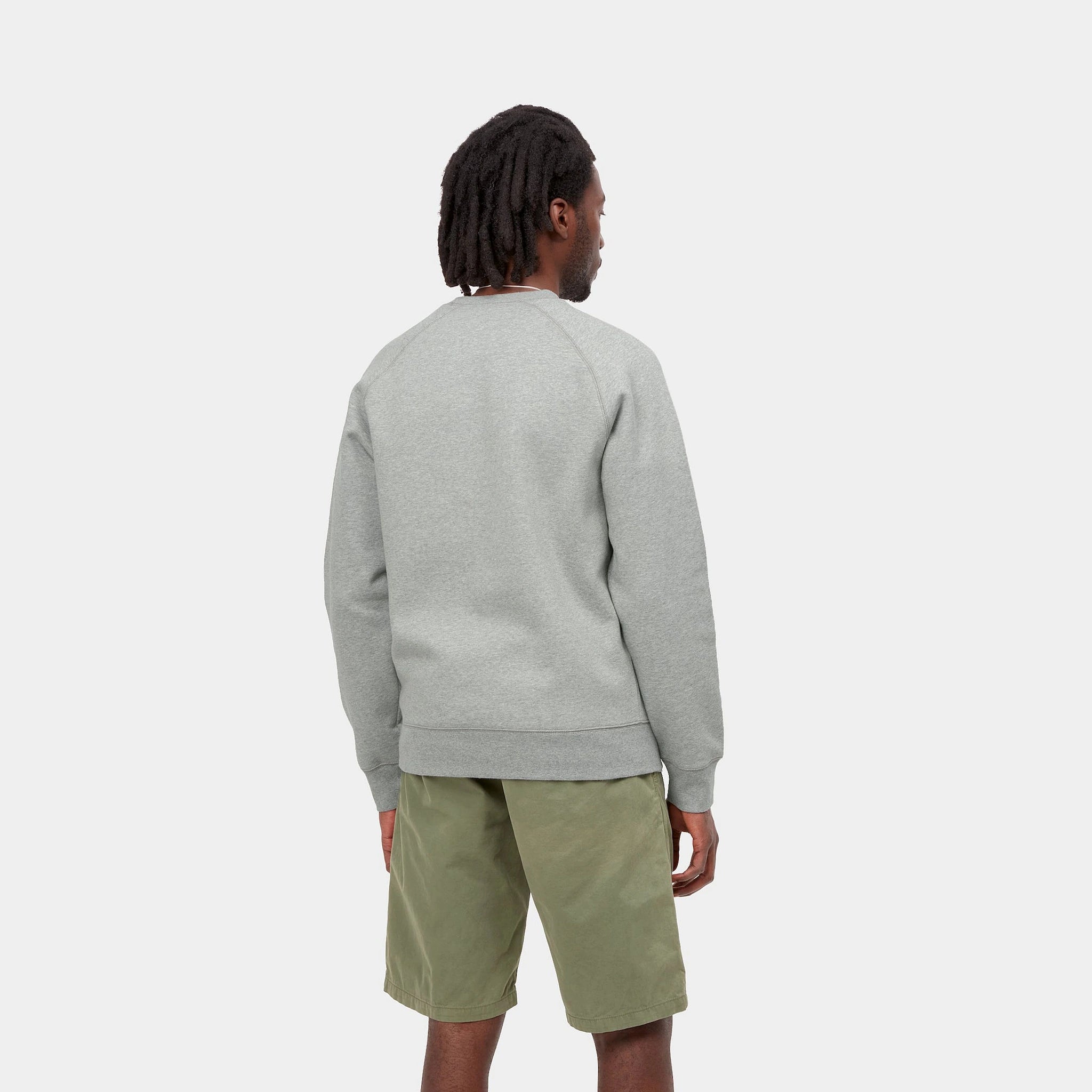 “Graumeliertes Carhartt WIP Chase Sweatshirt mit kleinem, goldenem "C"-Logo auf dem linken Ärmel. Klassischer Schnitt, Rundhalsausschnitt, gerippte Bündchen und Saum. Weicher Baumwollmix.“