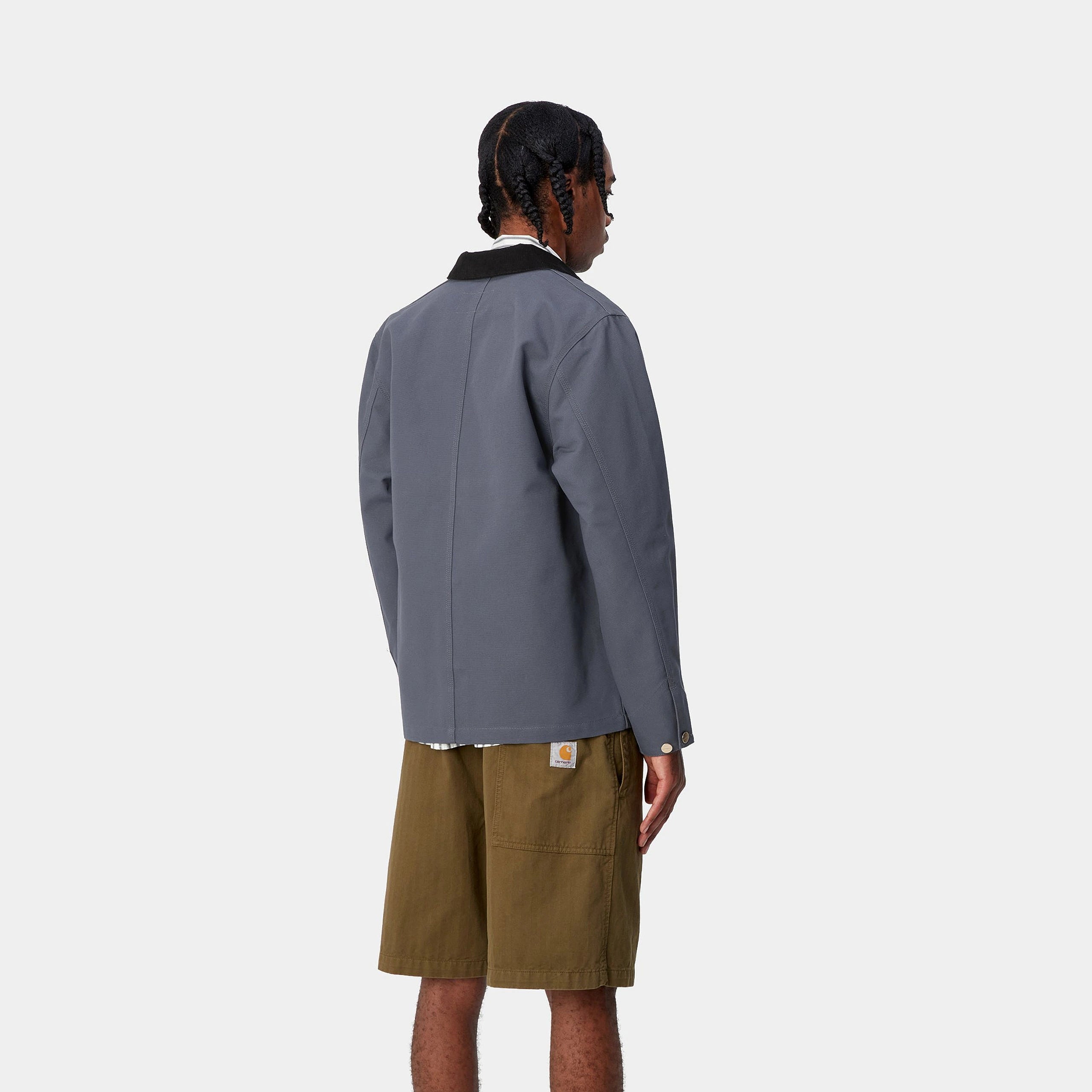 „Graublauer ("Zeus") Carhartt WIP Michigan Coat (Summer) mit schwarzem Kragen. Leichte Jacke aus robustem Baumwoll-Canvas, mit Knopfverschluss, vier aufgesetzten Taschen und gewebtem Square Label."
