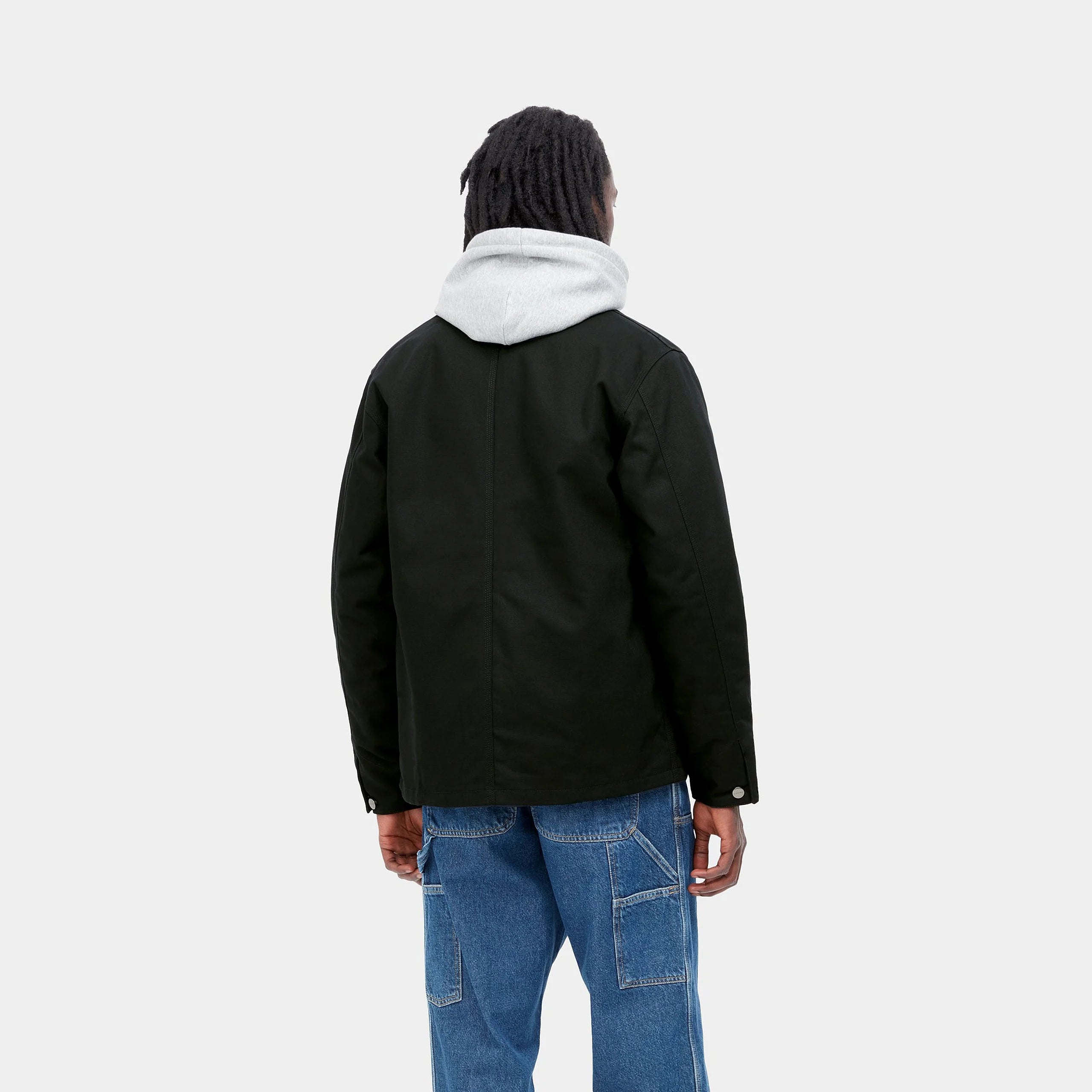 “Schwarzer ("rigid") Carhartt WIP Michigan Coat (Winter). Robuste Winterjacke aus ungefärbtem Baumwoll-Canvas, mit Steppfutter, Knopfverschluss und vier aufgesetzten Taschen.“