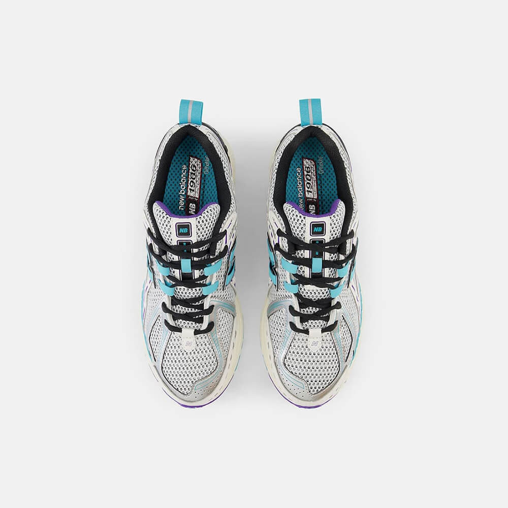 New Balance 1906R CF. Cremefarbener Sneaker mit lila und türkisen Akzenten. Obermaterial aus Mesh und Synthetik-Overlays mit goldener Fersenspange und ABZORB-Sohle.
