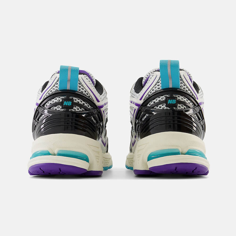 New Balance 1906R CF. Cremefarbener Sneaker mit lila und türkisen Akzenten. Obermaterial aus Mesh und Synthetik-Overlays mit goldener Fersenspange und ABZORB-Sohle.