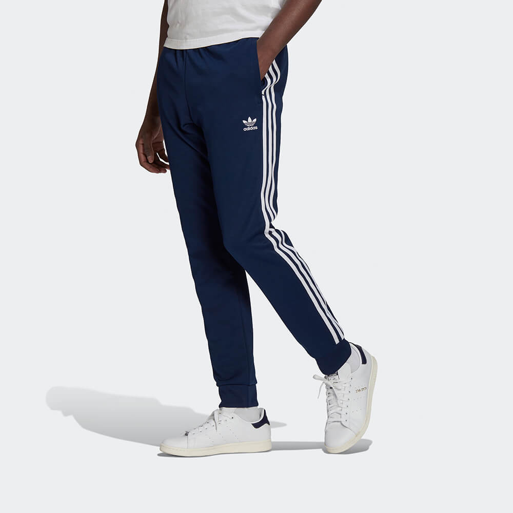 "Adidas Classics SST Track Pants in Blau, HK7353, aus Polyester/Baumwolle, schmal geschnitten, klassische adidas Trainingshose mit Streifen."