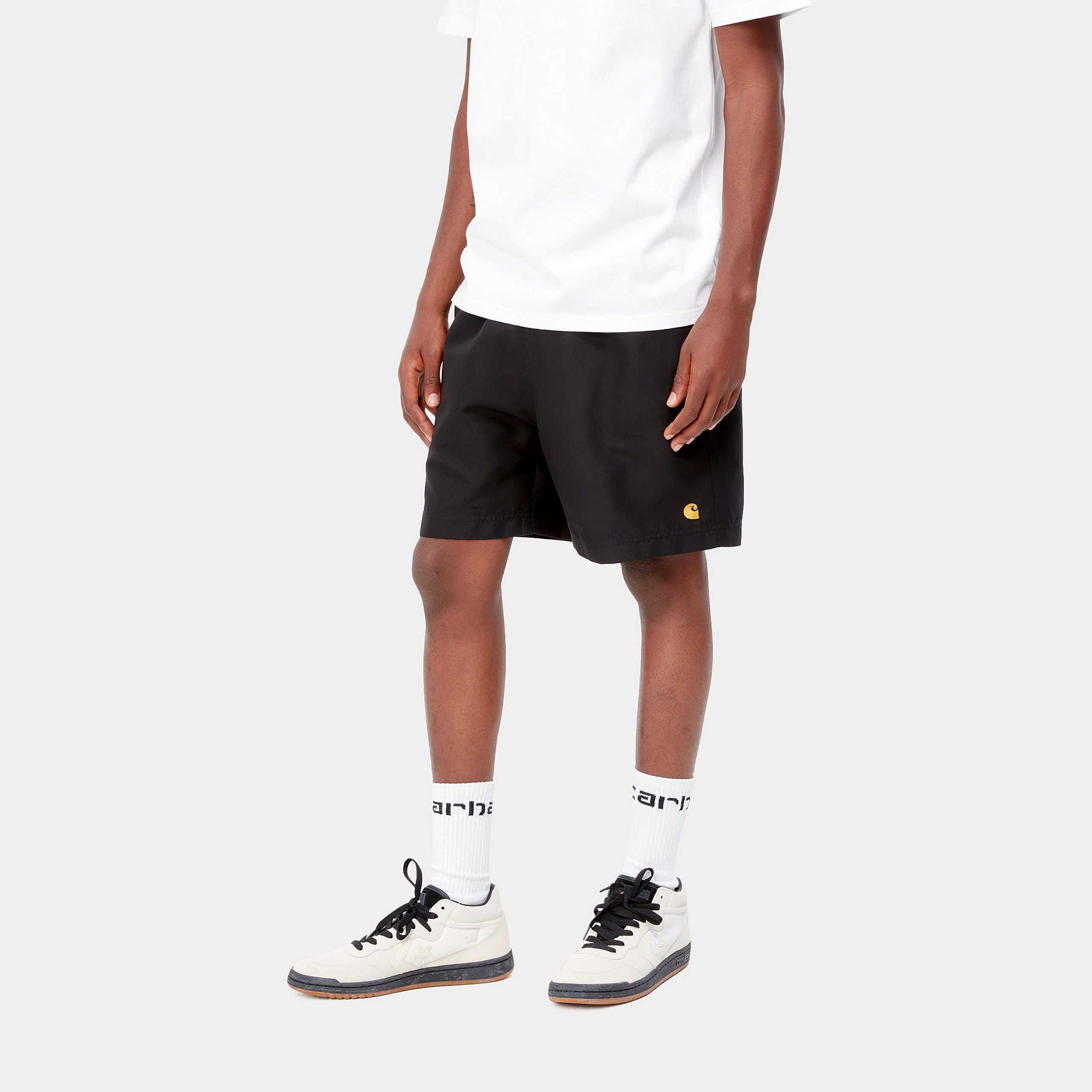 "Carhartt Chase Swim Trunk in Schwarz/Gold, Polyester, Badehose mit Kordelzug, goldene Logo-Stickerei."