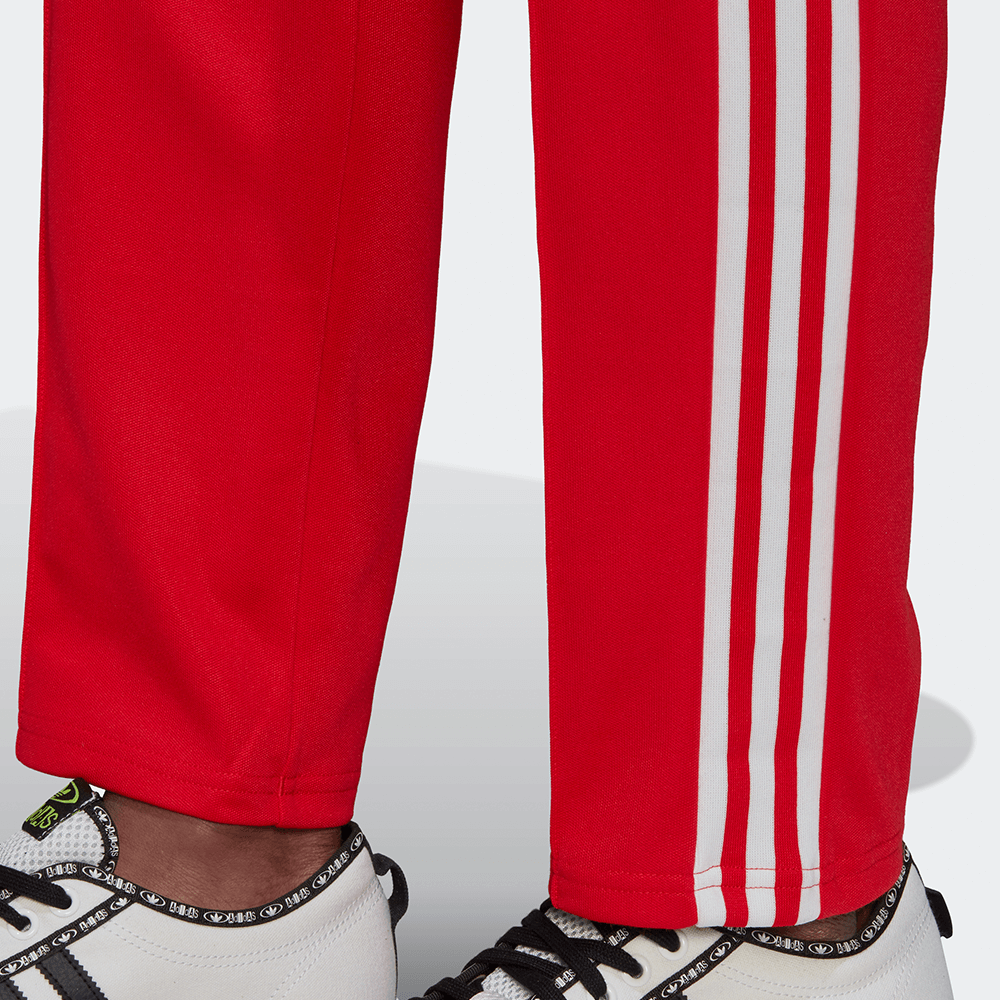 "Adidas Beckenbauer Track Pants in Vivid Red, Polyester-Mischung, klassische Trainingshose mit Streifen, leuchtend rote Farbe."