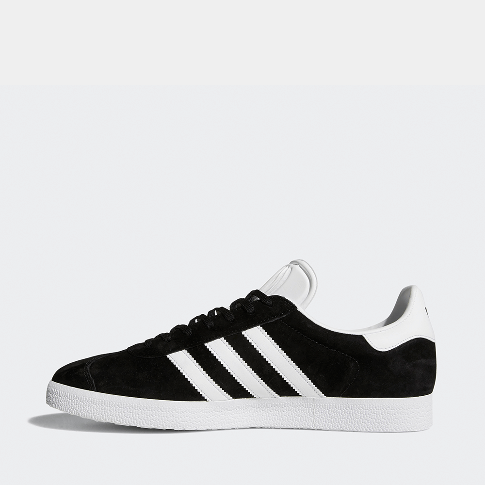"Adidas Gazelle, Core Black/Footwear White, Wildleder, klassischer Sneaker in Schwarz mit weißen Streifen und goldener 'Gazelle'-Aufschrift."