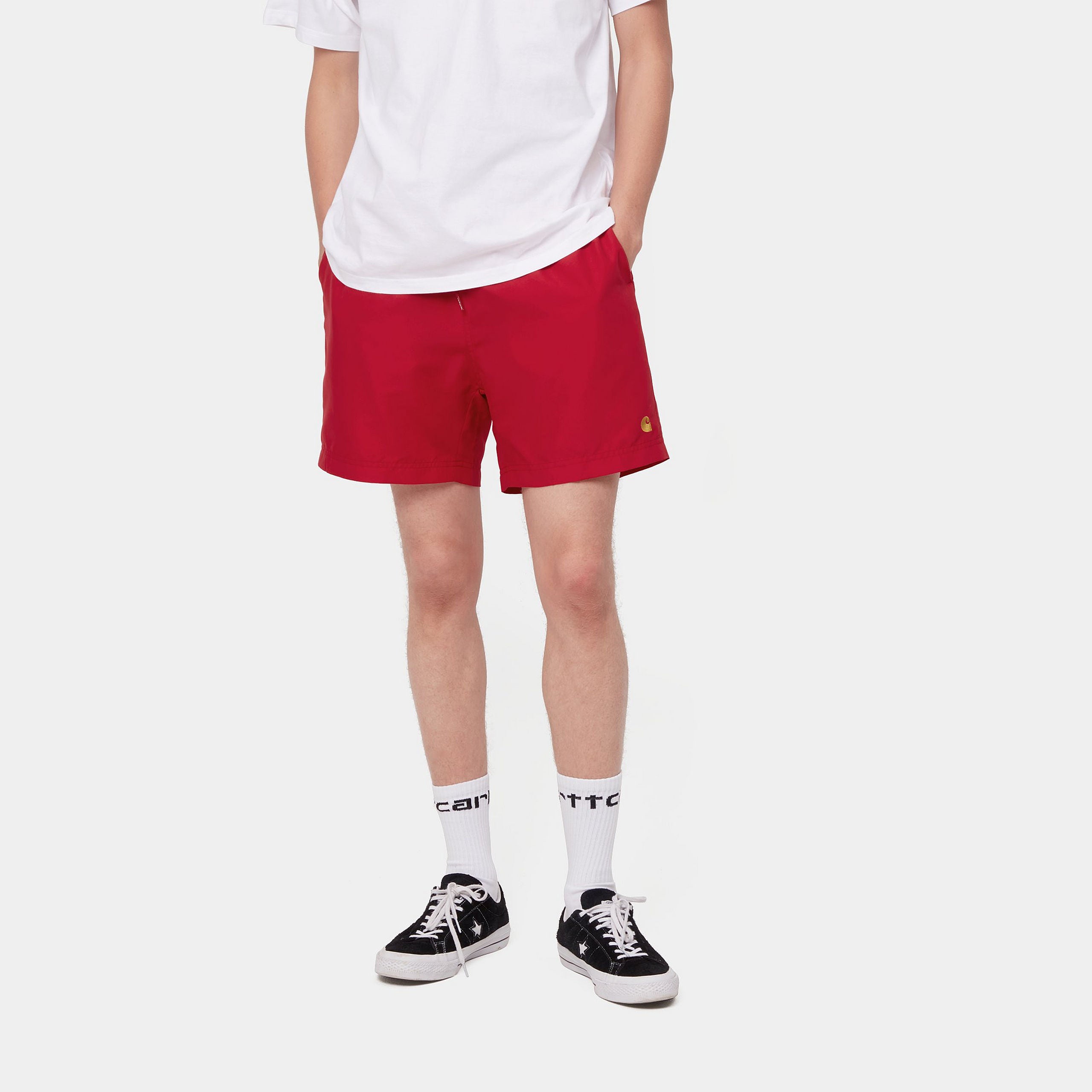 “Carhartt WIP Chase Swim Trunk – Cornel / Gold. Weinrote Badehose aus schnelltrocknendem Nylon mit Kordelzug und goldenem Logo-Stick.“