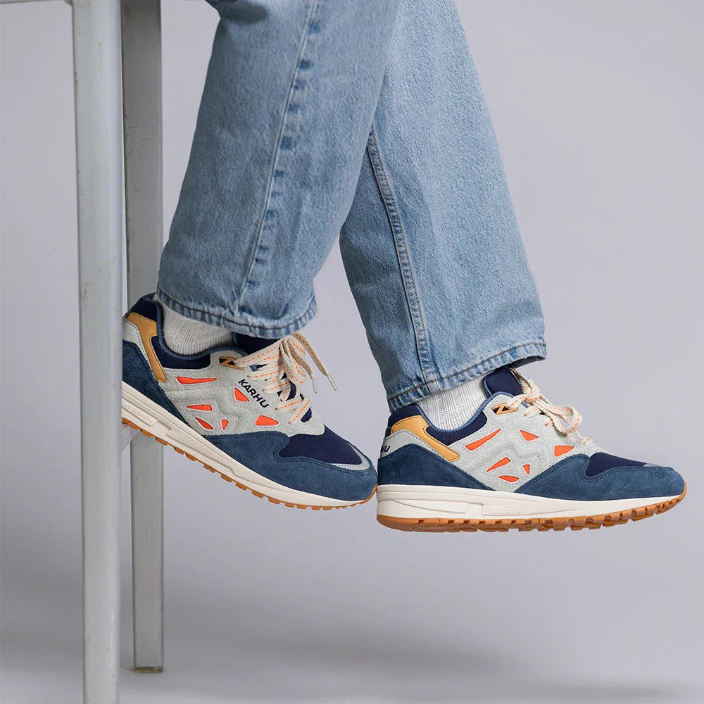 “Karhu Legacy 96 Sneaker in Indigo und Orange. Retro-Laufschuh aus Wildleder und Mesh, mit Air-Cushion-Dämpfung.“