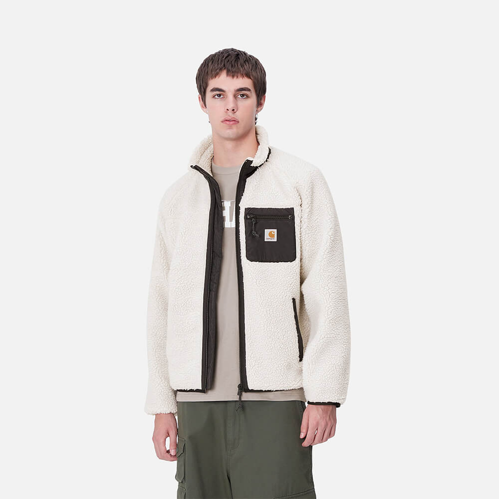 "Carhartt WIP Prentis Liner in Moonbeam/Black, aus weichem Teddyfleece, mit Kontrastdetails und Reißverschluss-Brusttasche."