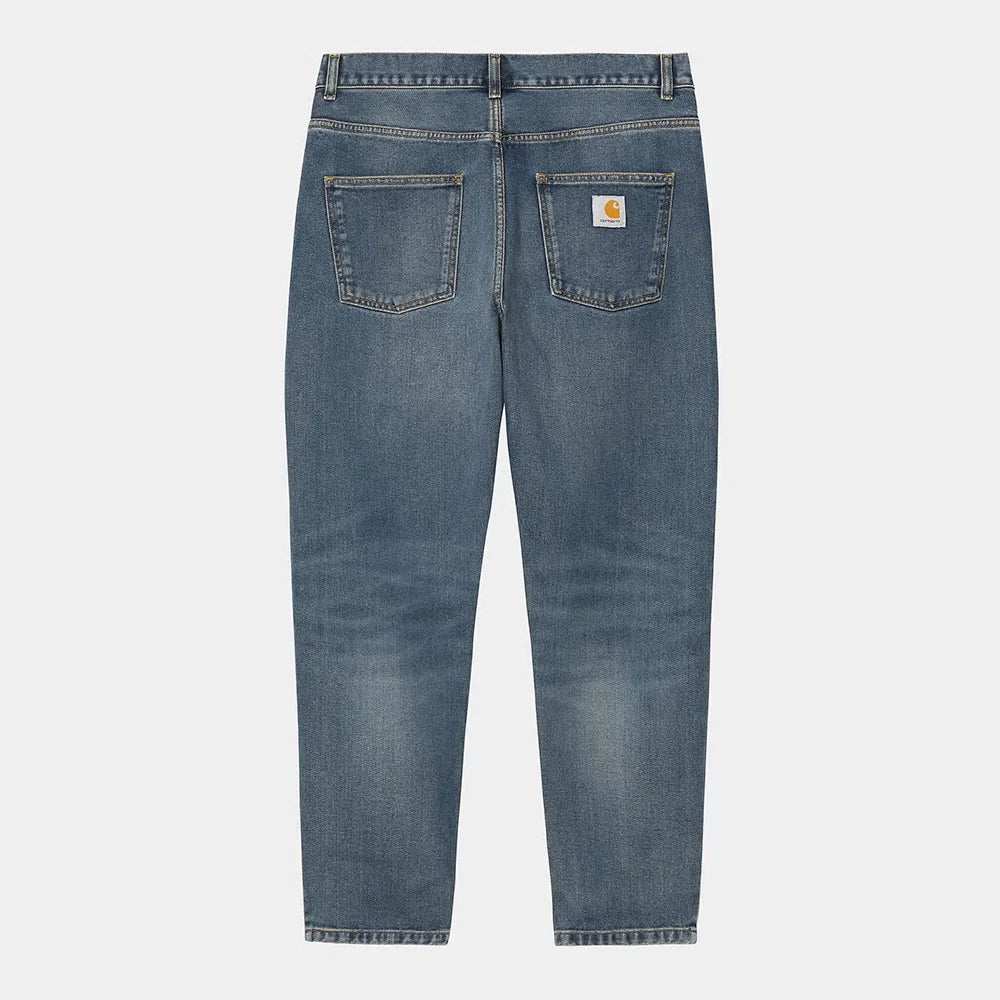 "Carhartt WIP Newel Pant – Blue (dark used wash). Dunkelblaue Jeans aus robustem Denim, mit lockerem Tapered Fit und Carhartt WIP Square Label auf der Gesäßtasche.“