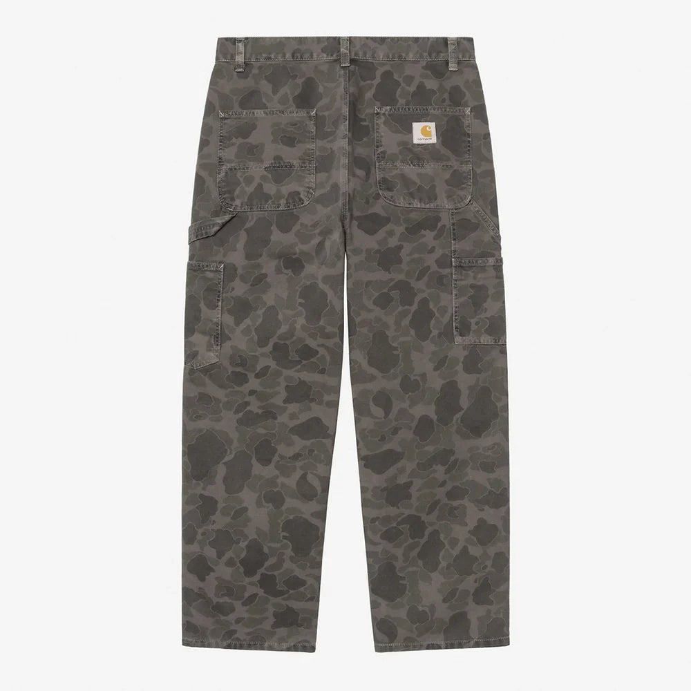 “Carhartt WIP Duck Single Knee Pant in Camo Duck. Robuste Workwear Canvas-Hose in Grün/Porphyr-Färbung mit Werkzeugtaschen und Hammerschlaufe.“