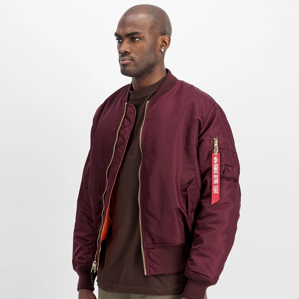 “Alpha Industries MA-1 Bomberjacke in Weinrot. Robuste Jacke aus Flight Nylon, mit orangefarbenem Innenfutter und Utility-Pocket am Ärmel bei Stickabush.“