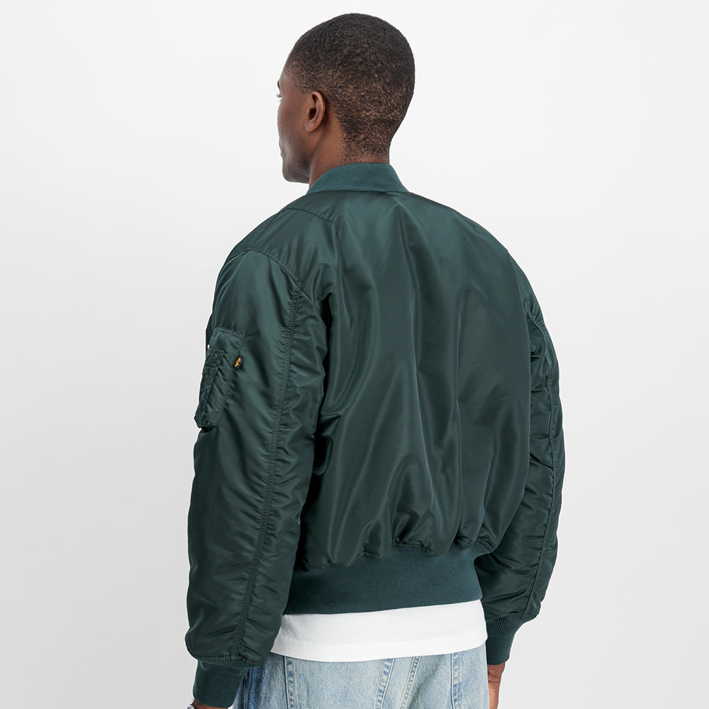 “Alpha Industries MA-1 (HERITAGE) Bomberjacke in Navy Green, aus robustem Nylon, mit orangem Innenfutter und klassischem Blouson-Schnitt bei Stickabush.“