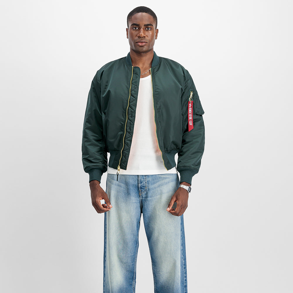 “Alpha Industries MA-1 (HERITAGE) Bomberjacke in Navy Green, aus robustem Nylon, mit orangem Innenfutter und klassischem Blouson-Schnitt bei Stickabush.“