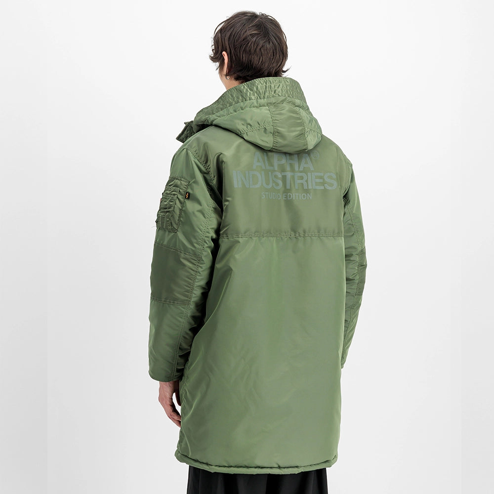 "Grüner Winterparka aus Nylon von Alpha Industries mit einem auffälligen Print auf dem Rücken und einer Teddyfutter-Kapuze bei Stickabush Berlin.“