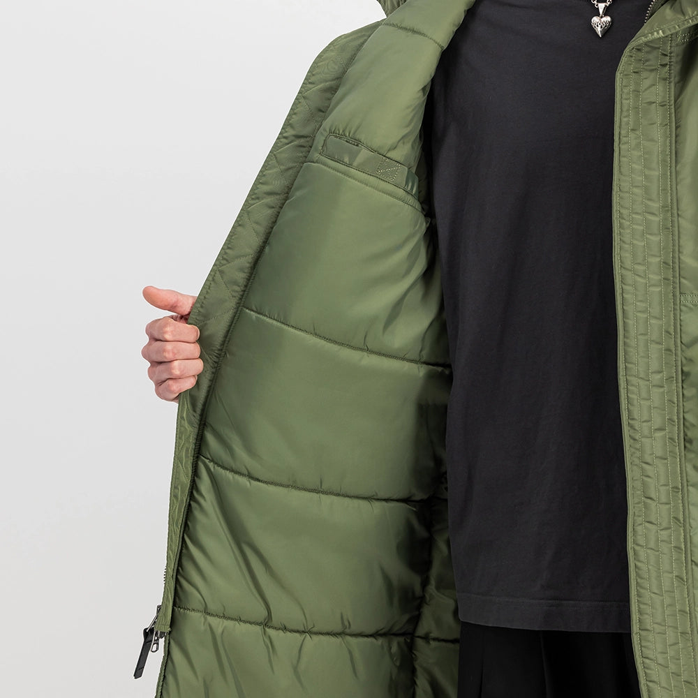 "Grüner Winterparka aus Nylon von Alpha Industries mit einem auffälligen Print auf dem Rücken und einer Teddyfutter-Kapuze bei Stickabush Berlin.“
