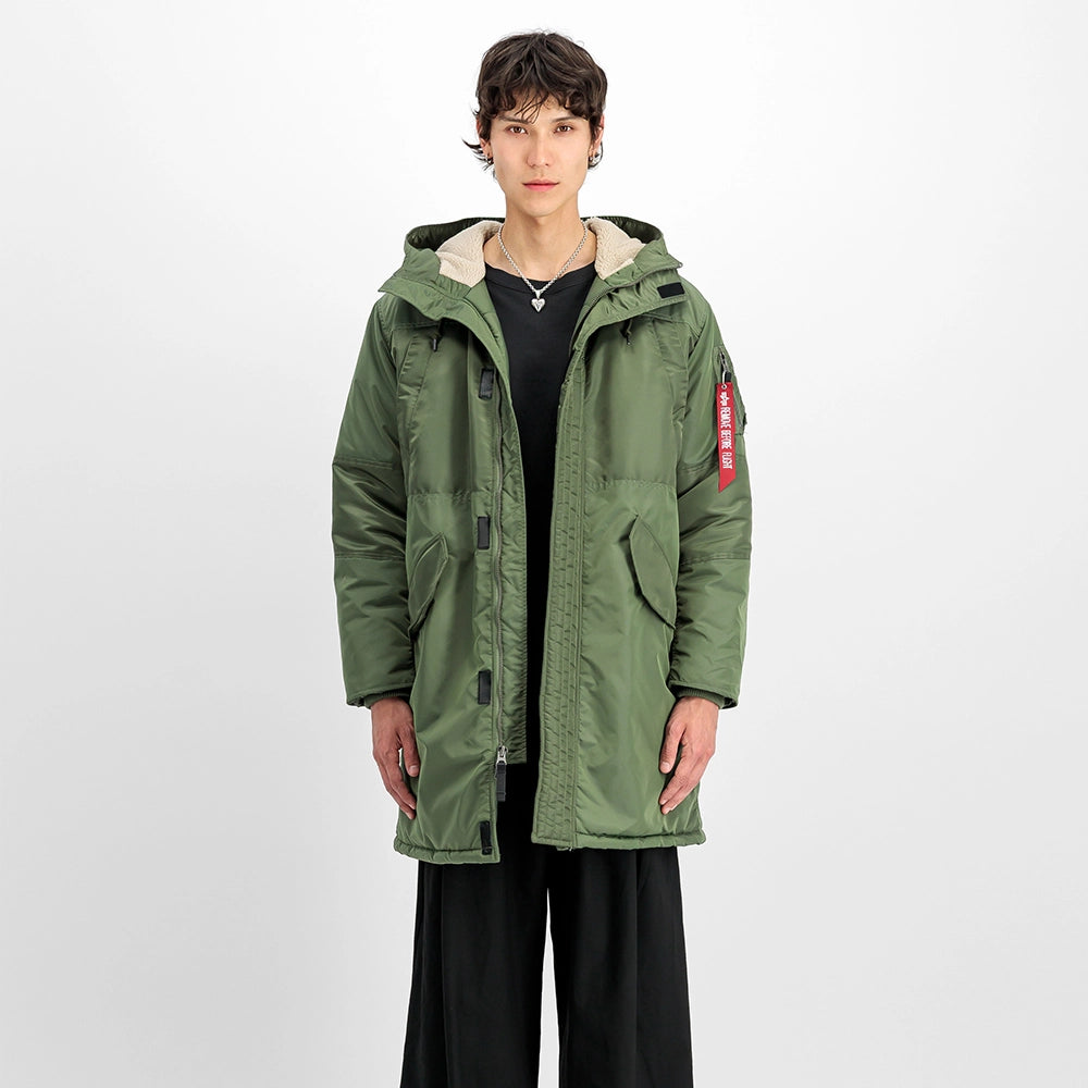 "Grüner Winterparka aus Nylon von Alpha Industries mit einem auffälligen Print auf dem Rücken und einer Teddyfutter-Kapuze bei Stickabush Berlin.“