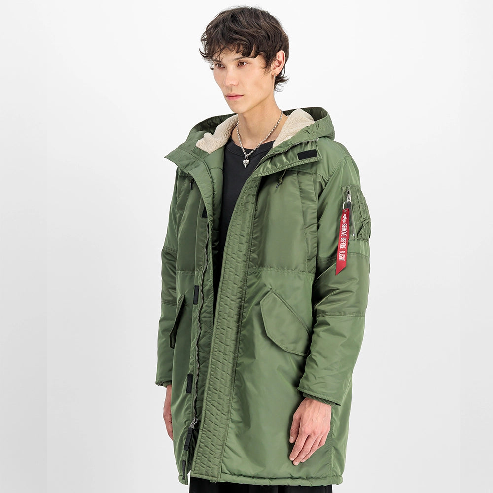 "Grüner Winterparka aus Nylon von Alpha Industries mit einem auffälligen Print auf dem Rücken und einer Teddyfutter-Kapuze bei Stickabush Berlin.“