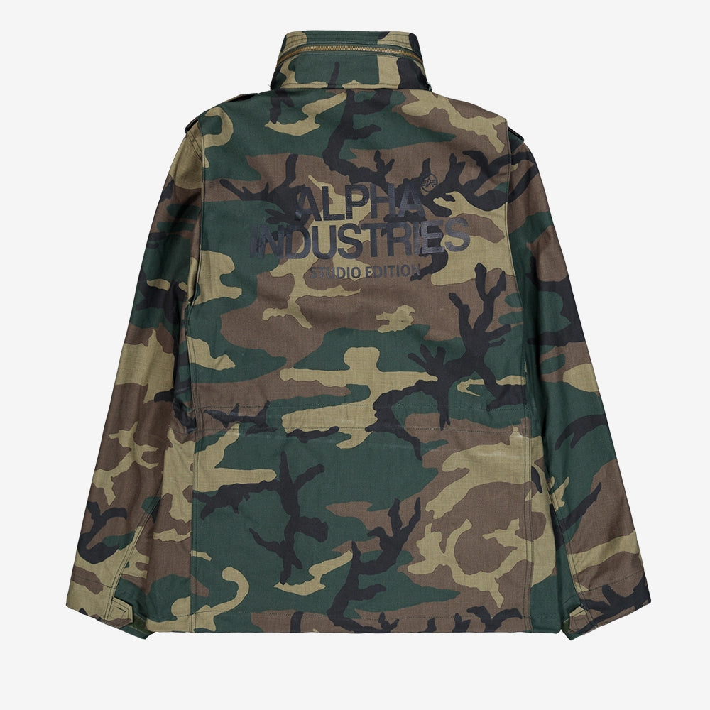 "Camouflage-Feldjacke aus Baumwoll-Mischung von Alpha Industries. Mit vier Pattentaschen, verdeckter Kapuze und Logo-Print auf dem Rücken.“
