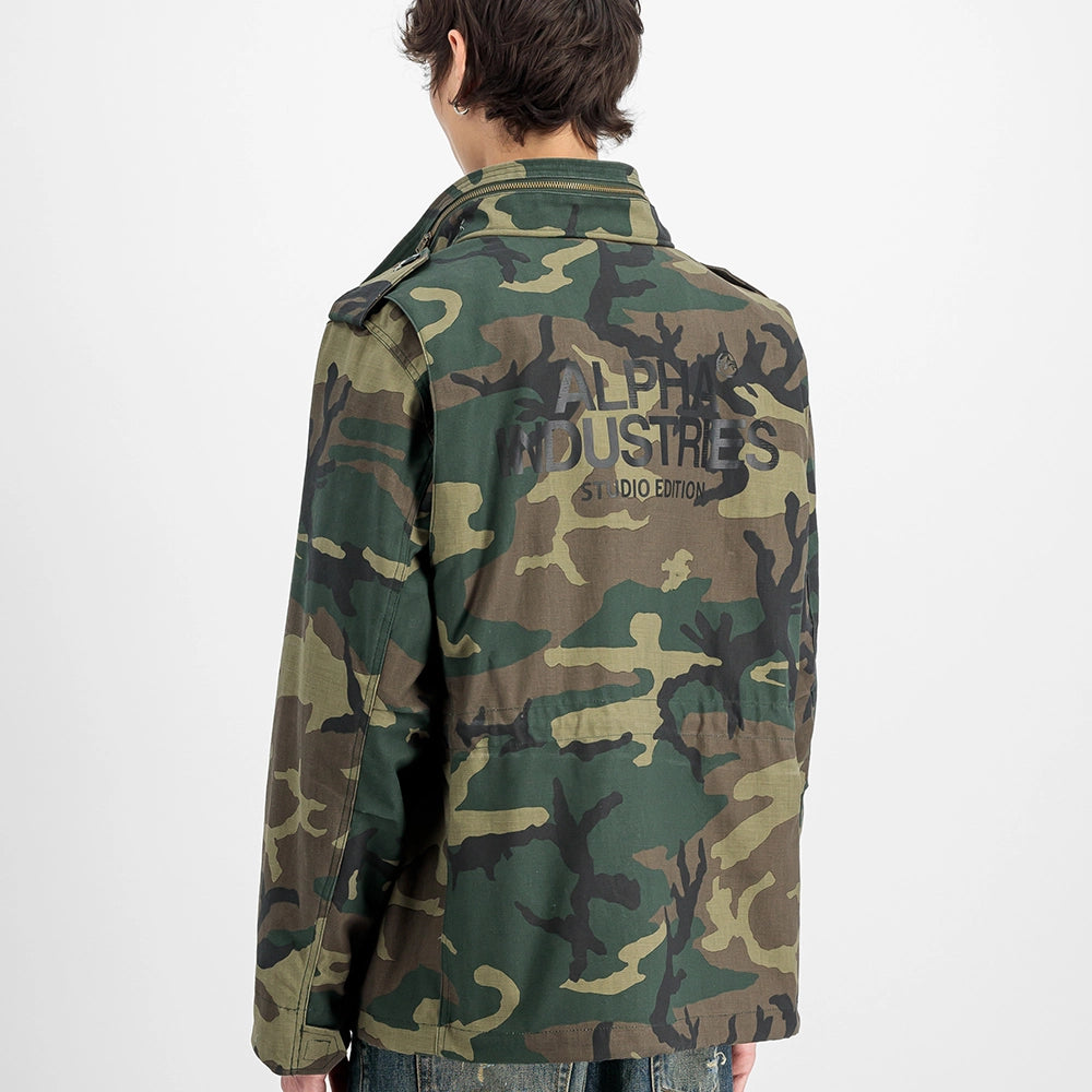 "Camouflage-Feldjacke aus Baumwoll-Mischung von Alpha Industries. Mit vier Pattentaschen, verdeckter Kapuze und Logo-Print auf dem Rücken.“