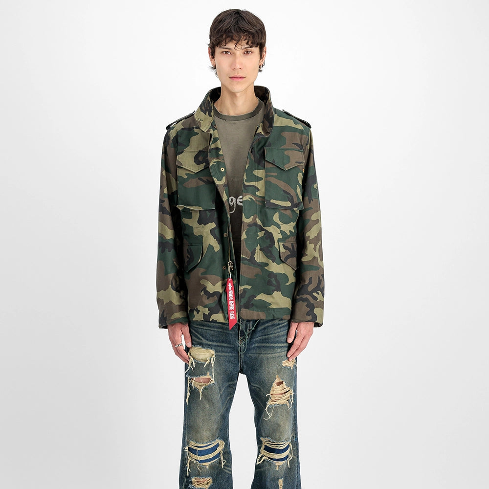 "Camouflage-Feldjacke aus Baumwoll-Mischung von Alpha Industries. Mit vier Pattentaschen, verdeckter Kapuze und Logo-Print auf dem Rücken.“