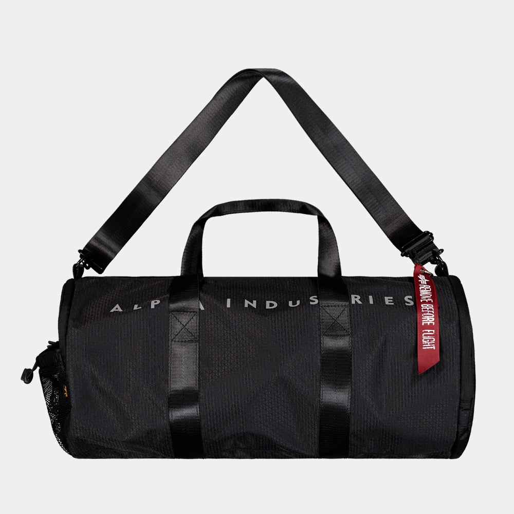 “Schwarze Alpha Industries Sporttasche aus Ripstop-Gewebe mit rotem Remove Before Flight Anhänger und stabilen Kordelzügen bei Stickabush Berlin.“