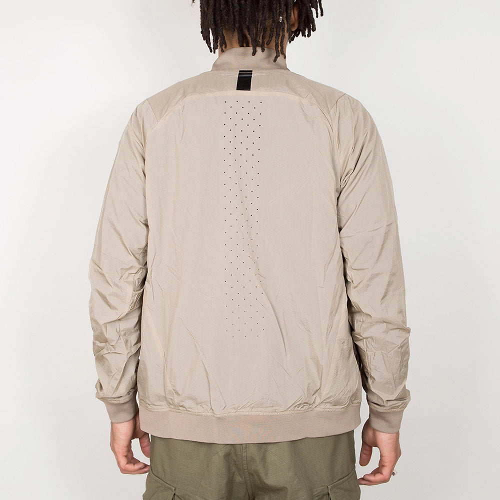“Nike Tech Hypermesh Varsity Jacket in Khaki. Jacke aus gewebtem Material und atmungsaktivem Mesh, mit schwarzen und weißen Akzenten.“