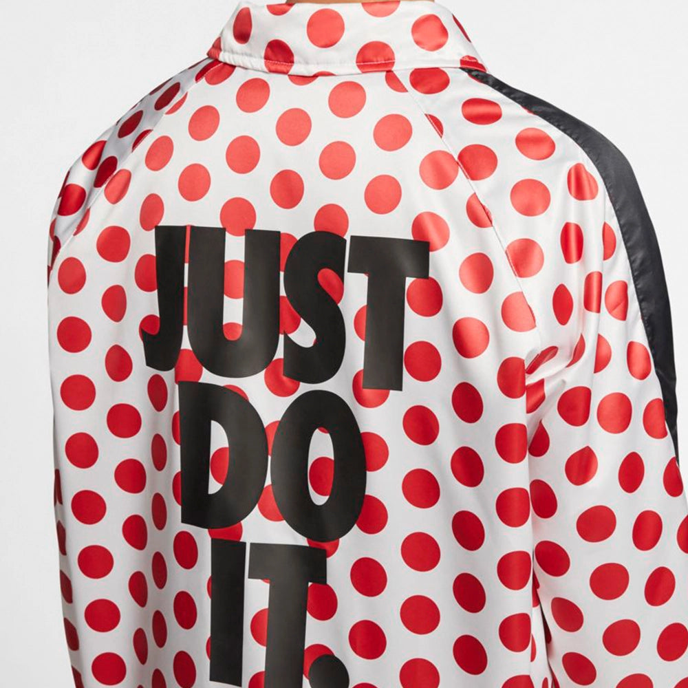 “Weiße Nike Winterjacke mit schwarzen Punkten (Polka Dots), schwarze Druckverschluss und großem Just Do It Schriftzug auf dem Rücken bei Stickabush Berlin.“