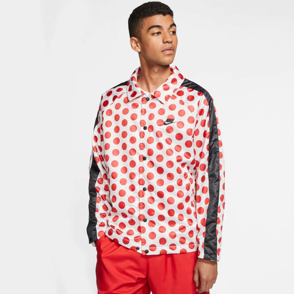 “Weiße Nike Winterjacke mit schwarzen Punkten (Polka Dots), schwarze Druckverschluss und großem Just Do It Schriftzug auf dem Rücken bei Stickabush Berlin.“