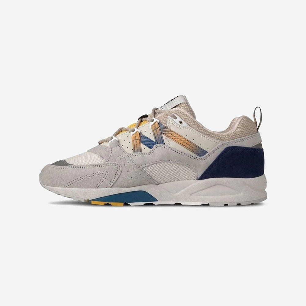 “Karhu Fusion 2.0 – Foggy Dew / True Navy. Graublauer Sneaker aus Wildleder und Mesh, mit reflektierenden Details, EVA-Zwischensohle und Karhu "M-Logo" an der Seite.“