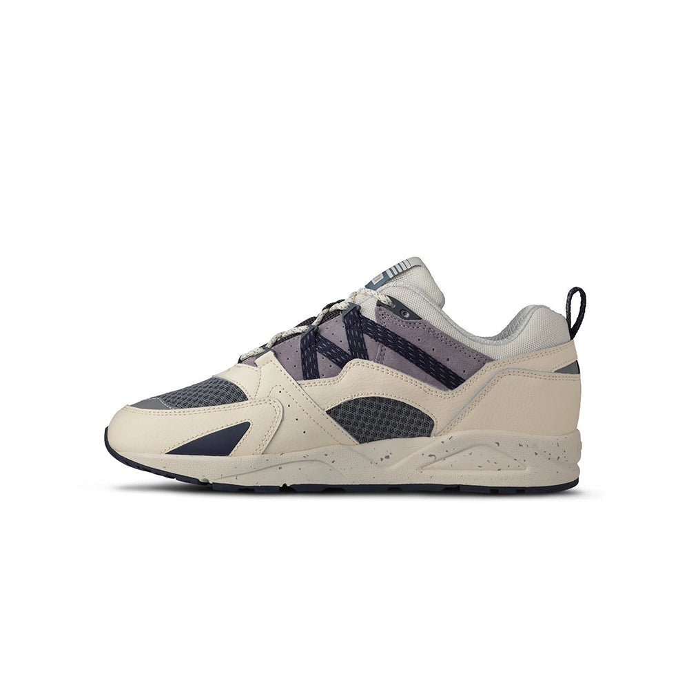 „Der Karhu Fusion 2.0 Herren Sneaker in Beige/Blaugrau/Lila (Naval Academy / Solitary Star) mit reflektierenden Details und praktischer Zuglasche und einer beigen Sohle bei Stickabush Berlin.“
