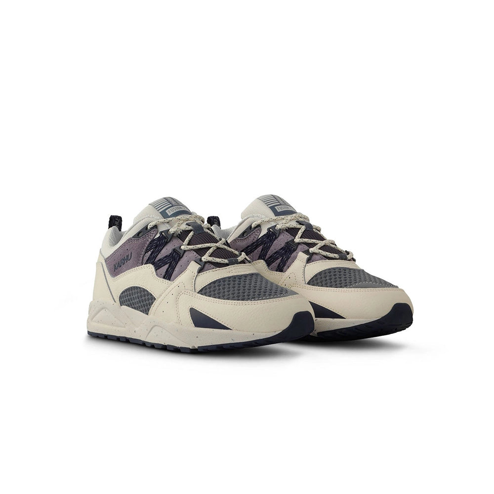 „Der Karhu Fusion 2.0 Herren Sneaker in Beige/Blaugrau/Lila (Naval Academy / Solitary Star) mit reflektierenden Details und praktischer Zuglasche und einer beigen Sohle bei Stickabush Berlin.“
