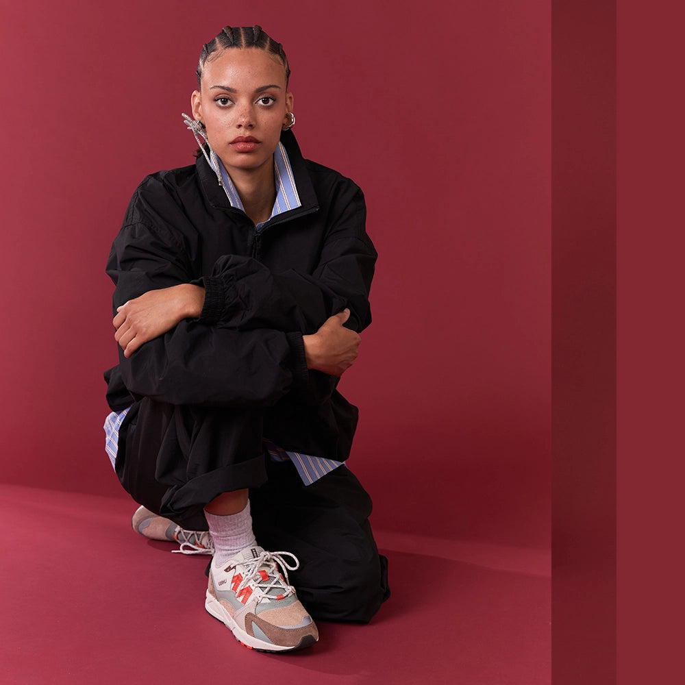 "Wildleder-Sneaker in warmen Braun- und Orangetönen mit beigem Mesh und dem Karhu 'M'-Logo.“
