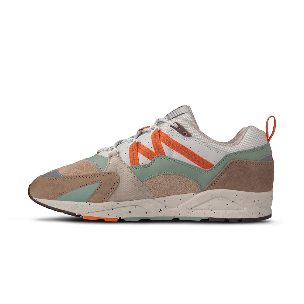 "Wildleder-Sneaker in warmen Braun- und Orangetönen mit beigem Mesh und dem Karhu 'M'-Logo.“
