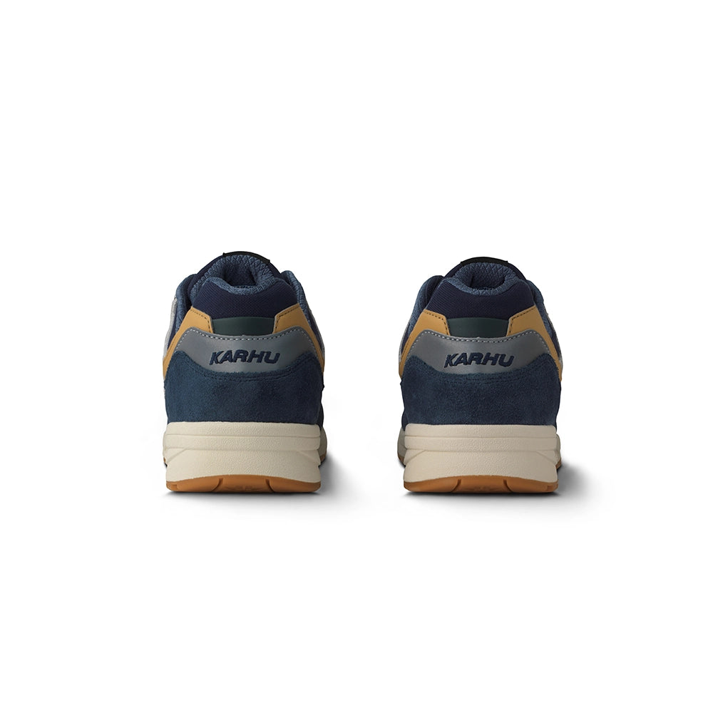 “Karhu Legacy 96 Sneaker in Indigo und Orange. Retro-Laufschuh aus Wildleder und Mesh, mit Air-Cushion-Dämpfung.“