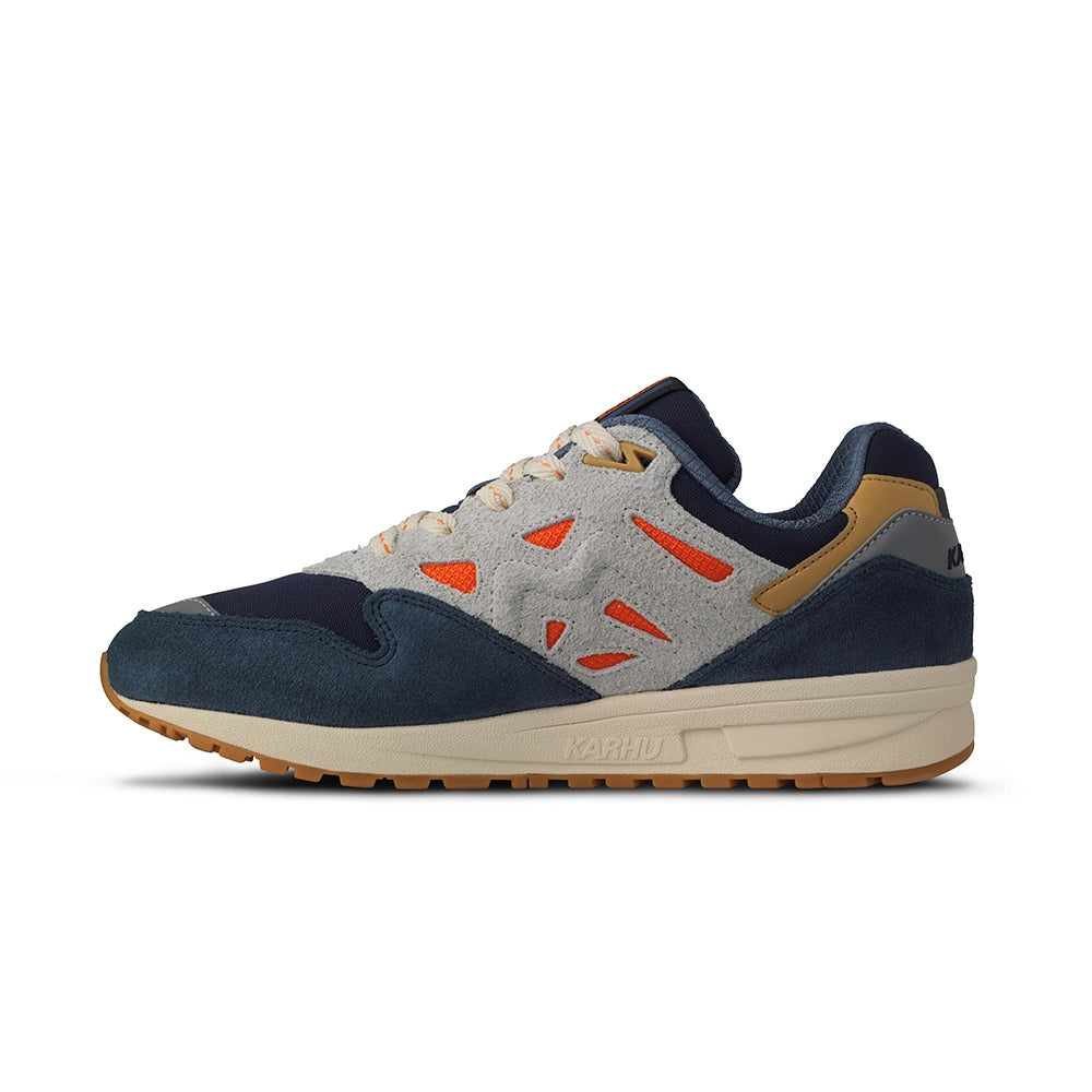 “Karhu Legacy 96 Sneaker in Indigo und Orange. Retro-Laufschuh aus Wildleder und Mesh, mit Air-Cushion-Dämpfung.“