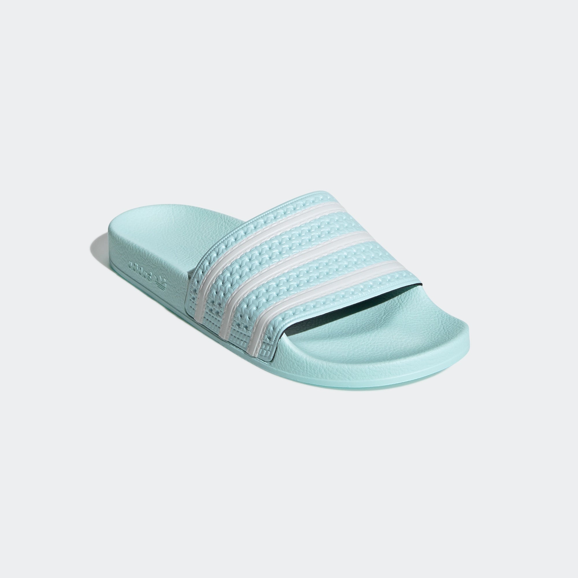 "Adidas Adilette – Halo Mint / Cloud White. Mintgrüne Badesandale aus synthetischem Material, mit breitem Riemen, geformtem Fußbett und weißen Adidas 3-Streifen." 