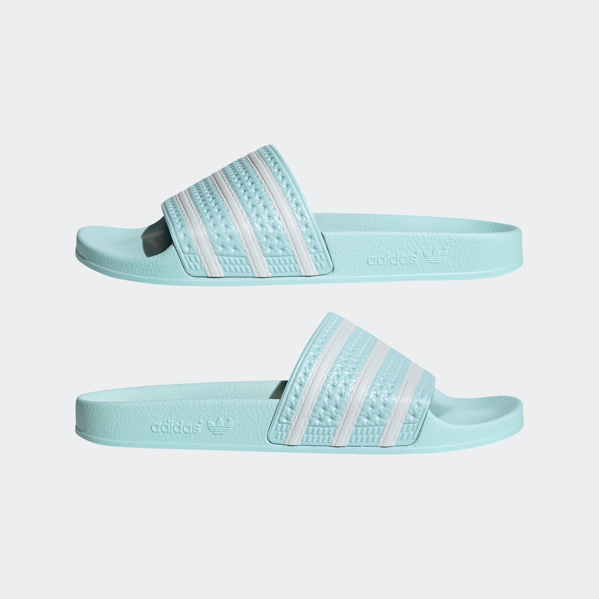 "Adidas Adilette – Halo Mint / Cloud White. Mintgrüne Badesandale aus synthetischem Material, mit breitem Riemen, geformtem Fußbett und weißen Adidas 3-Streifen." 