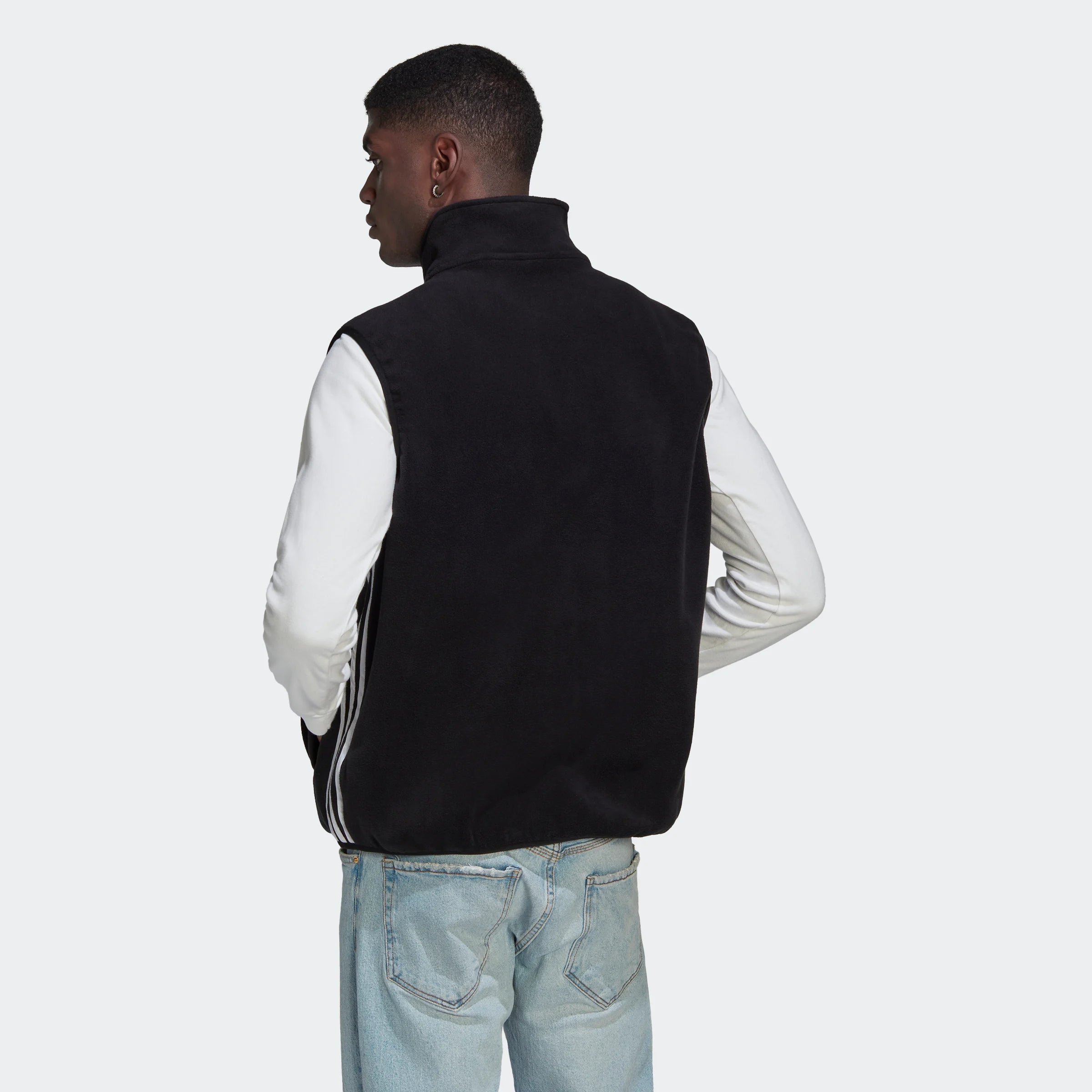 "Schwarze Adidas Fleeceweste mit weißen 3-Streifen an den Seiten. Ärmellos, durchgehender Reißverschluss, Stehkragen. Weiches Fleece-Material."