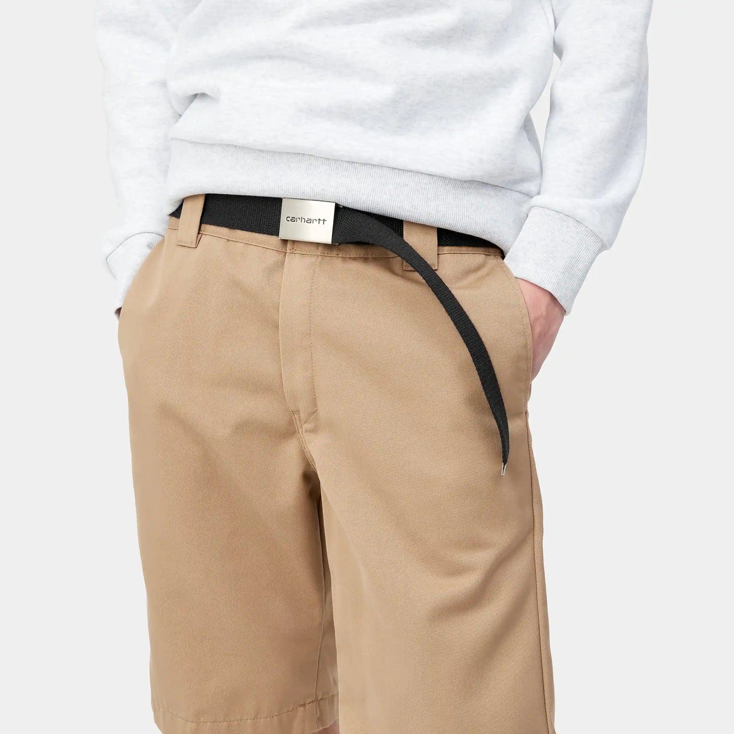 "Carhartt WIP Clip Belt Chrome – Black. Schwarzer Gürtel aus strapazierfähigem Polyester-Gurtband, mit silberner Clip-Schnalle und eingeprägtem Carhartt WIP Schriftzug."
