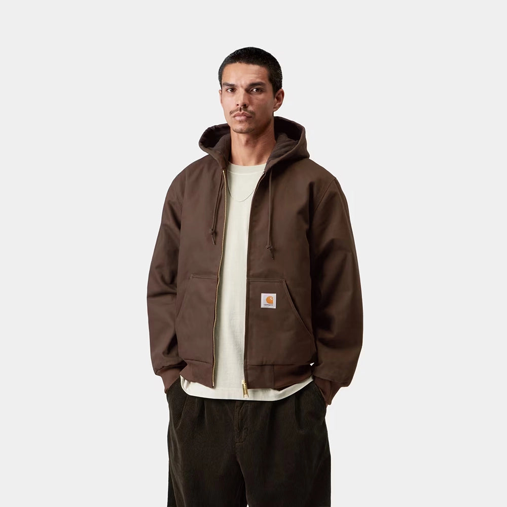 Carhartt WIP Active Jacket Winter in Tobacco – Vorderansicht am Model der braunen Canvas-Winterjacke mit Kapuze und wärmendem Thinsulate-Futter.
