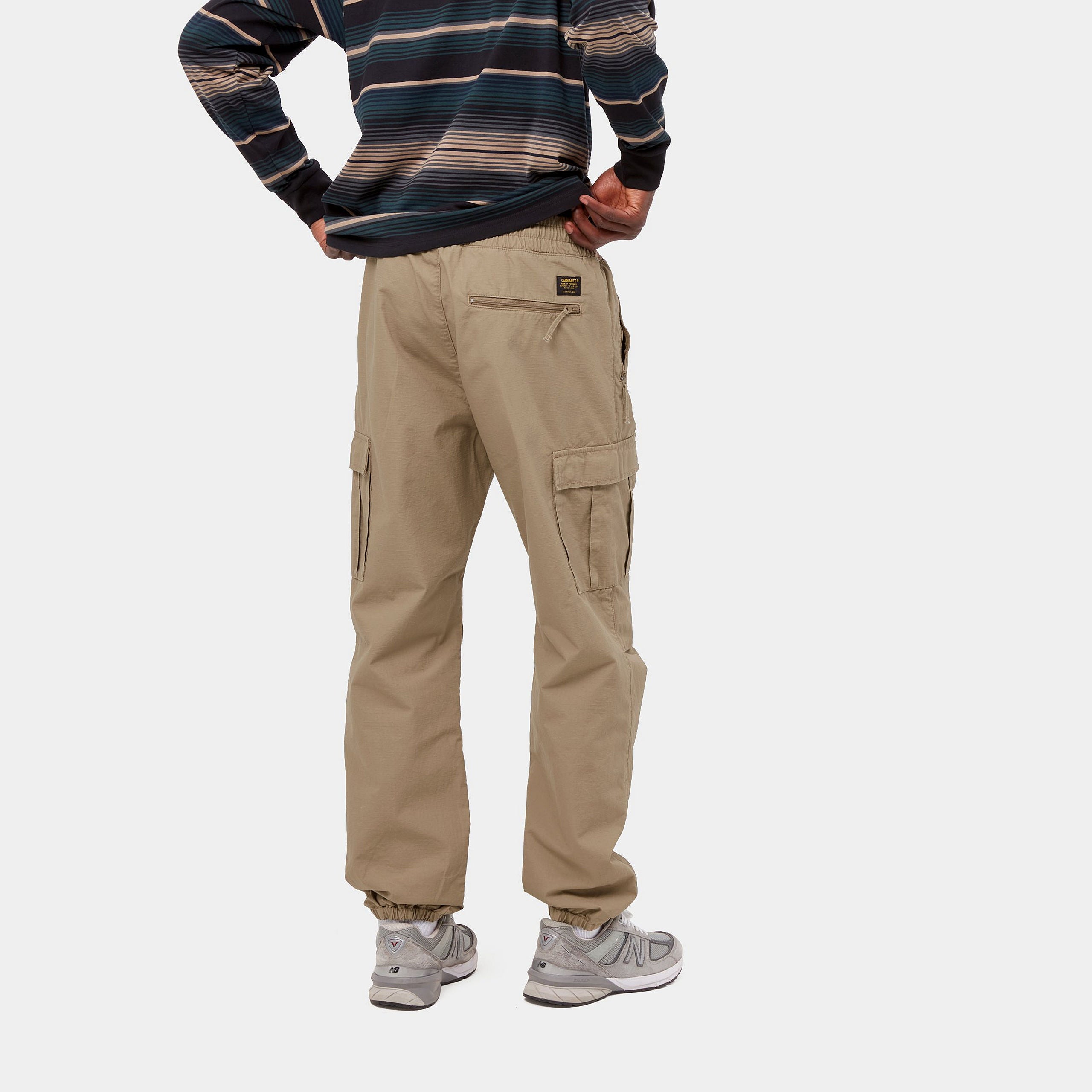 Carhartt WIP Cargo Jogger in Leather (rinsed), robuste braune Baumwollhose mit seitlichen Cargo-Taschen, elastischem Bund und Beinbündchen im Tapered Fit.