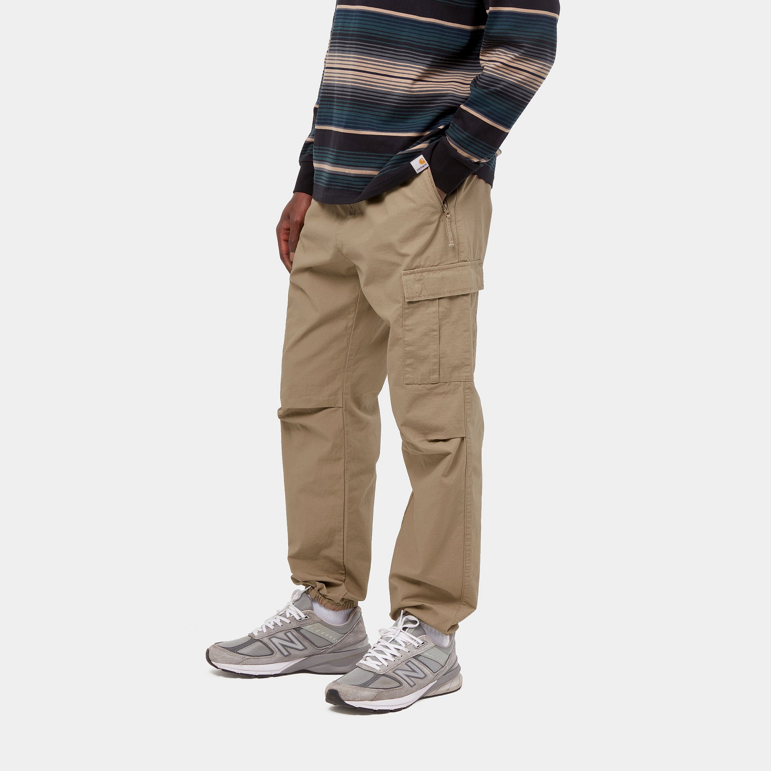 Carhartt WIP Cargo Jogger in Leather (rinsed), robuste braune Baumwollhose mit seitlichen Cargo-Taschen, elastischem Bund und Beinbündchen im Tapered Fit.