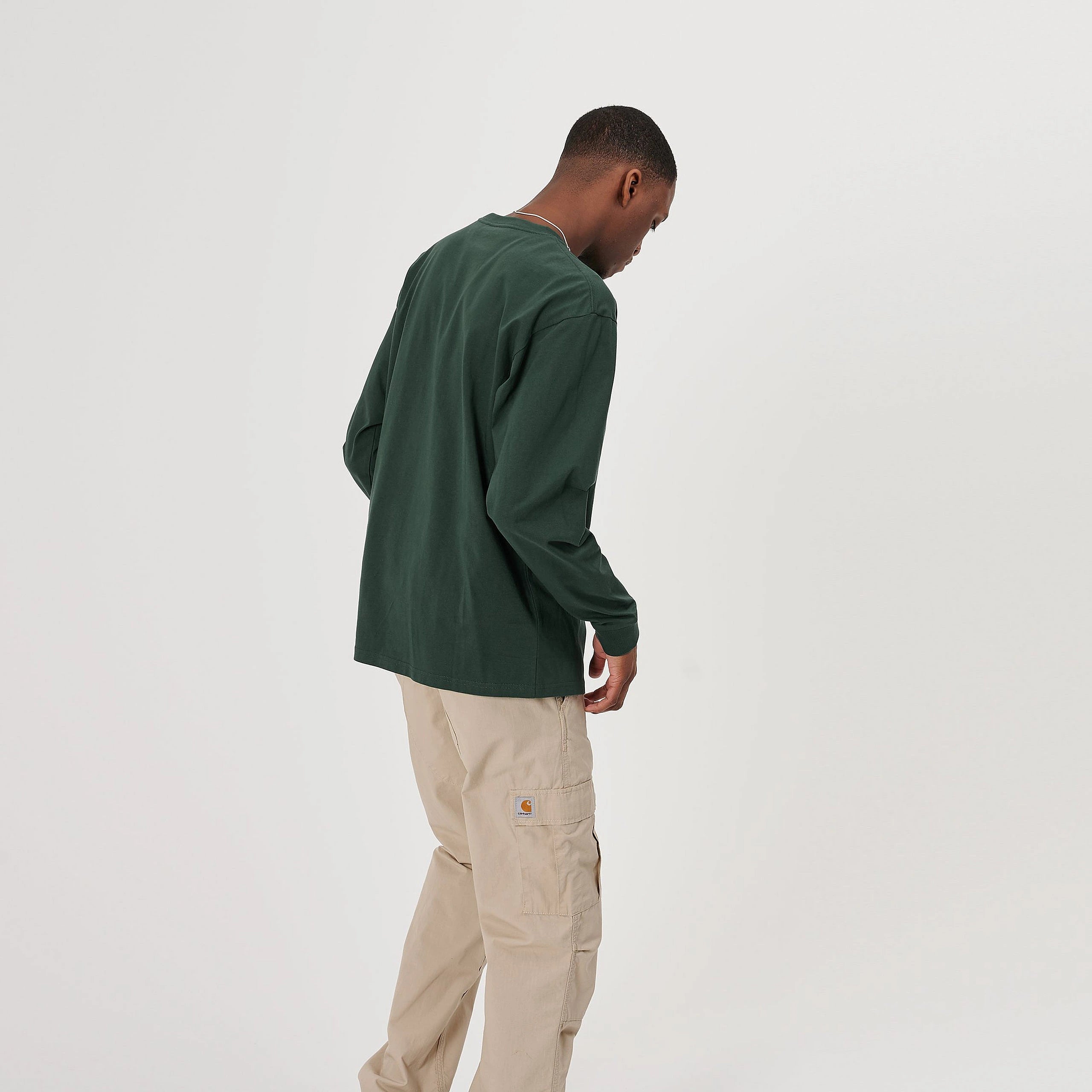 “Carhartt WIP L/S Chase T-Shirt – Treehouse / Gold. Grünes Langarmshirt aus Baumwoll-Jersey, mit Rundhals und gesticktem, goldenem Carhartt WIP Logo am Ärmel.“